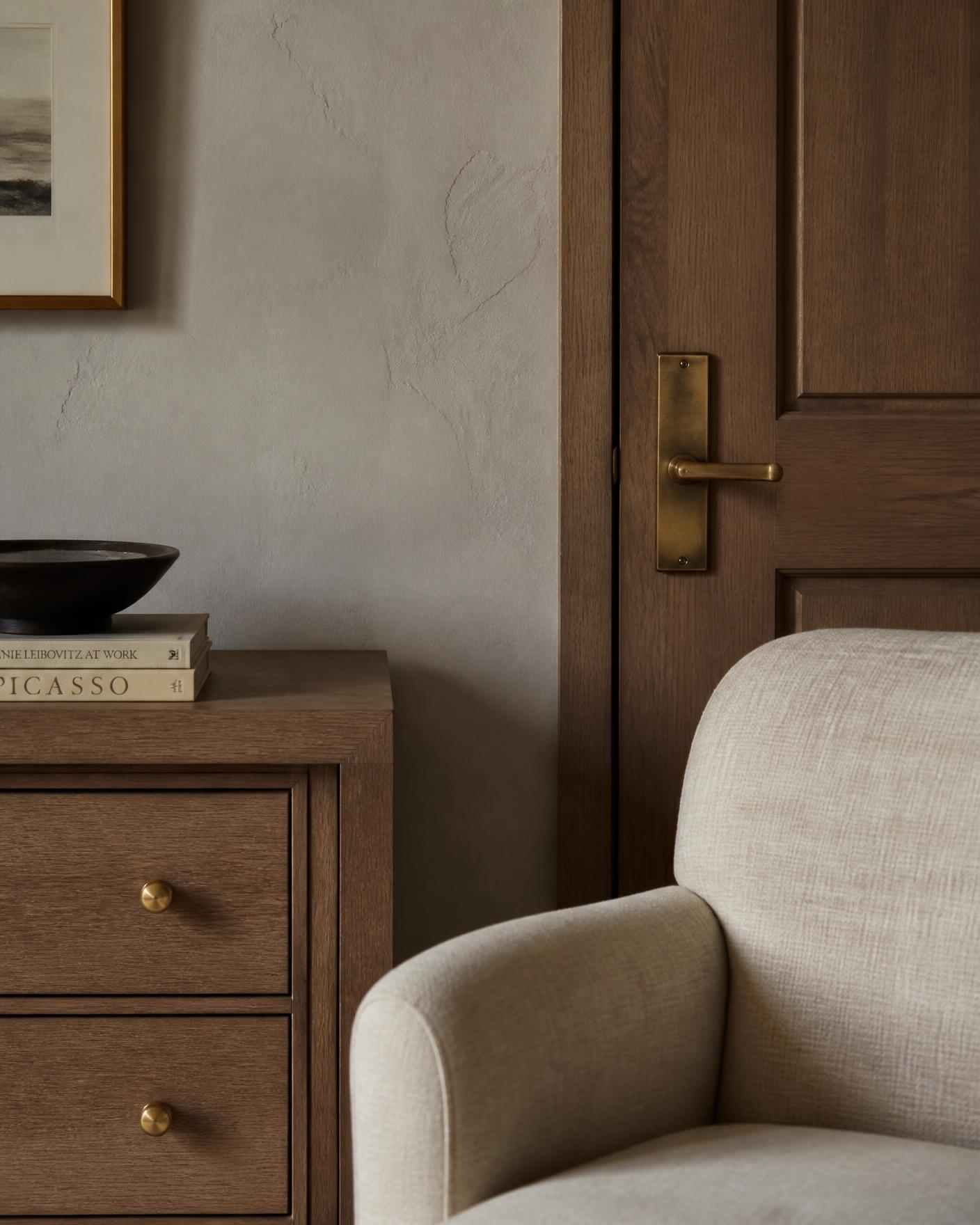 A quiet interior with oak millwork, linen upholstery and soft natural light